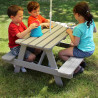 Table de pique-nique en bois pour enfant - Picnic - Enfants assis sur la table qui s'amusement dans un jardin