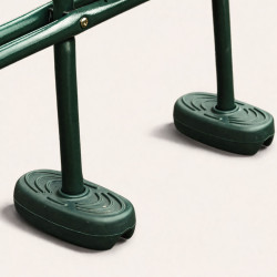 Vue zoom des cales pieds d'une balançoire face à face en métal avec assises en bois