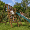 Enfant jouant sur la balançoire en bois HERA Soulet avec toboggan et espace escalade dans le jardin