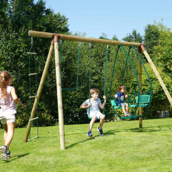 Scène d’ambiance dans un jardin avec un enfant sur la balancelle et une balançoire simple du portique en bois Julie 4 agrès